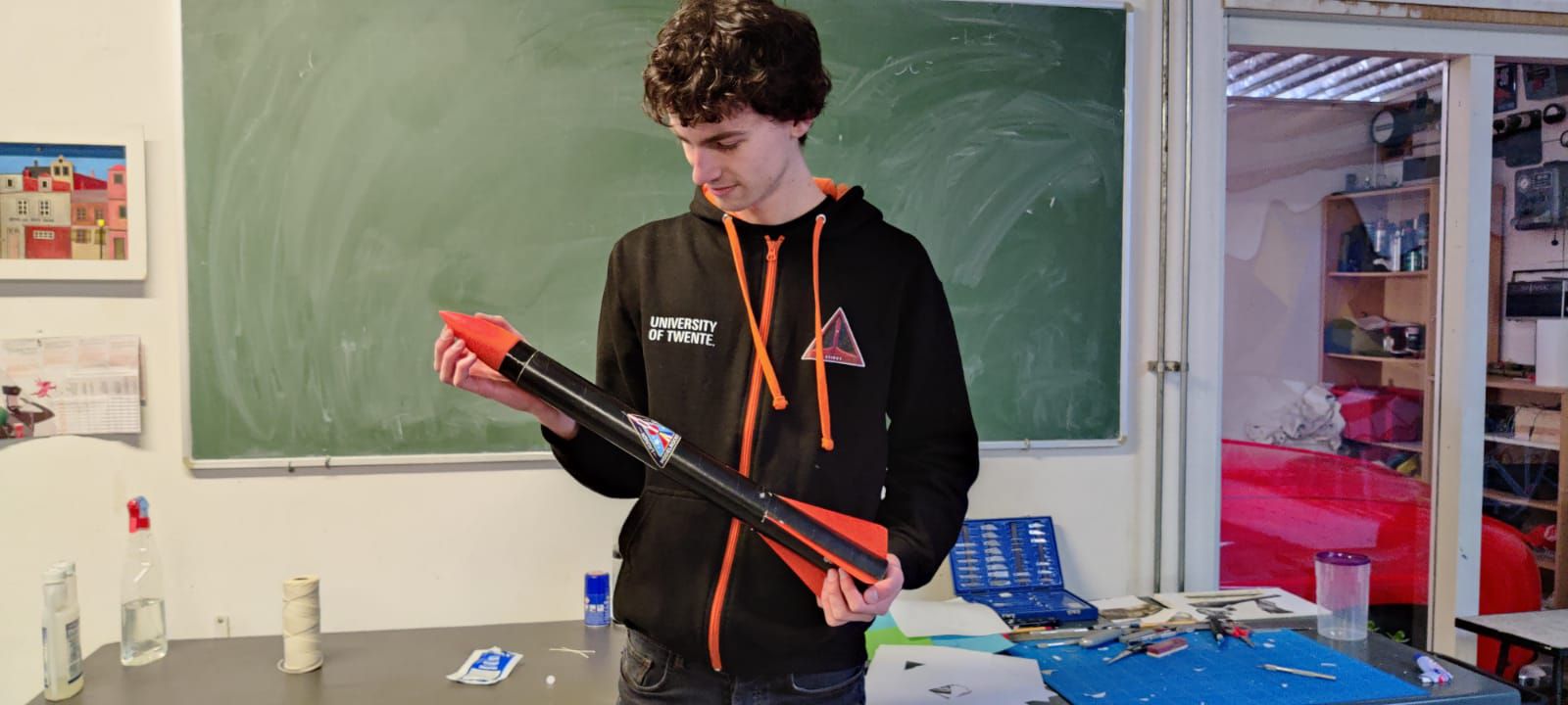 Ivan Ouderkerk, the Engineering Lead, holding the rocket prototype